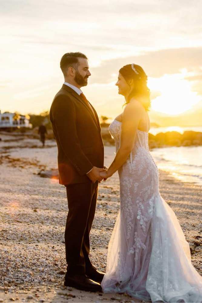 Newlyweds facing each other in warm sunset light