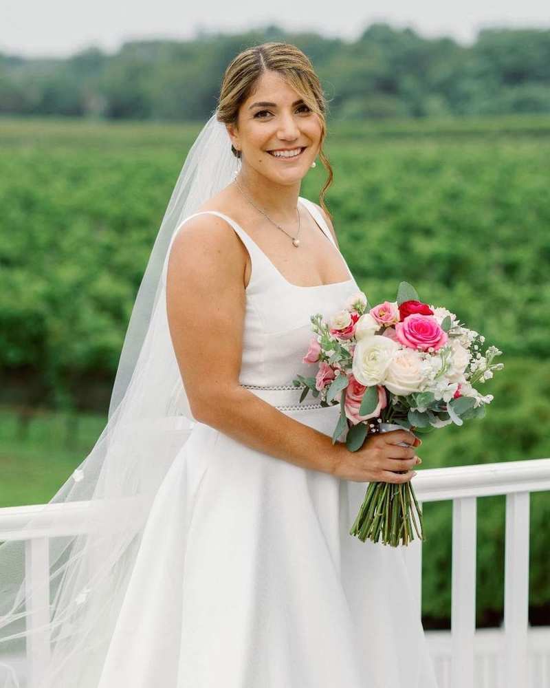 Bride holding a pink-and-white bouquet at a North Fork vineyard wedding