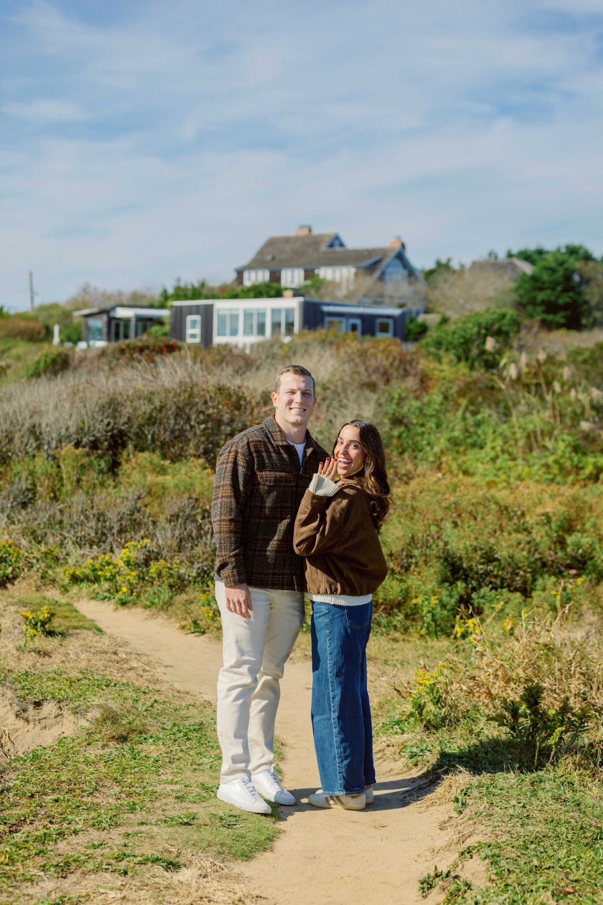 Engagement photos at Shadmoor State Park, Montauk, Long Island — a newly engaged couple on the dune path just after she said yes, showing the ring