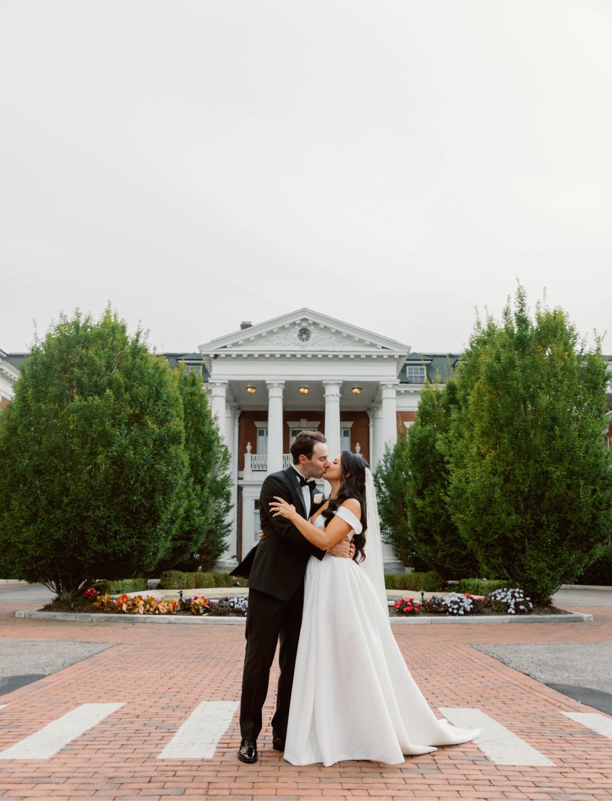 Newlyweds standing together before Bourne Mansion in Oakdale