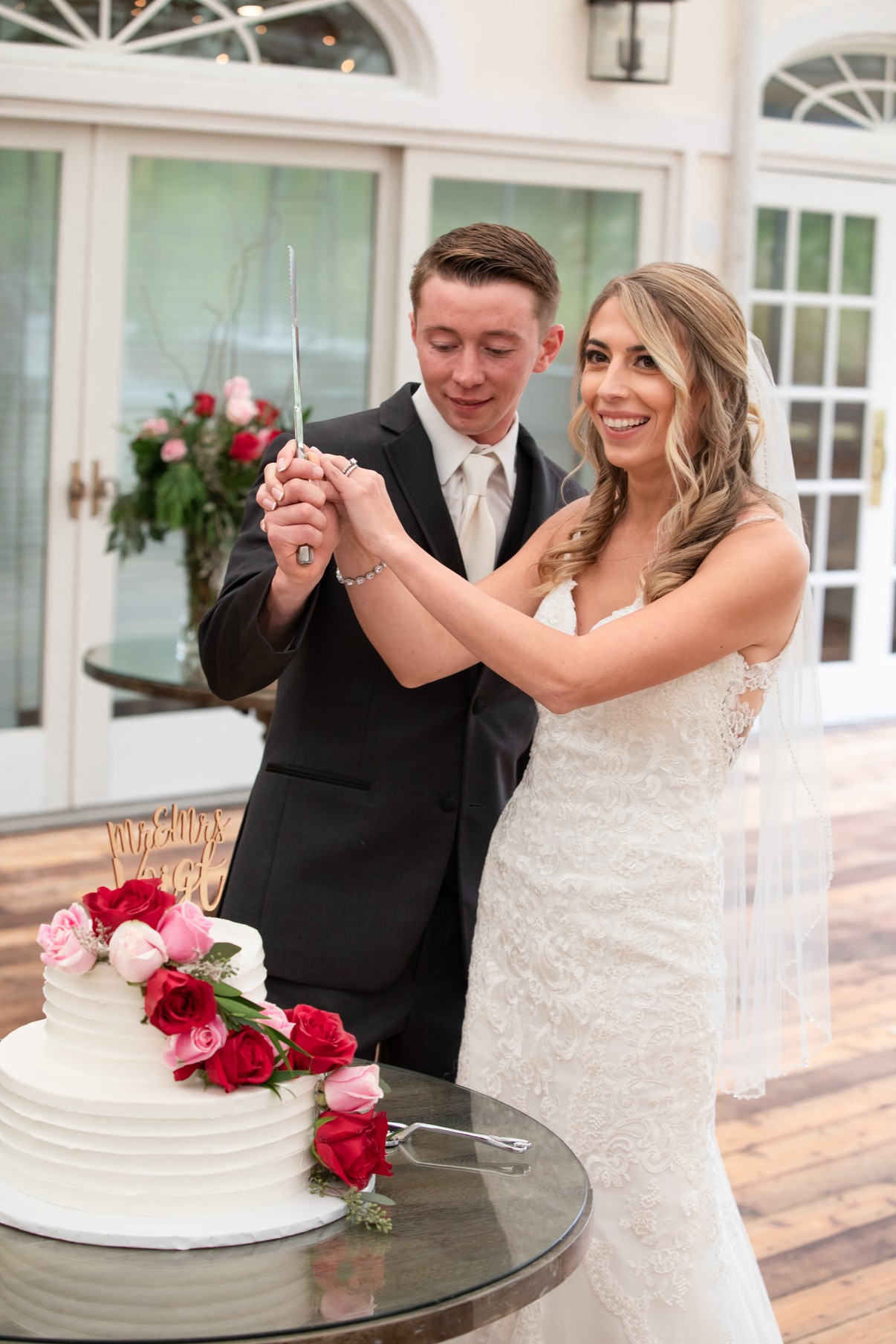 Bride and groom holding the knife together as they cut their wedding cake