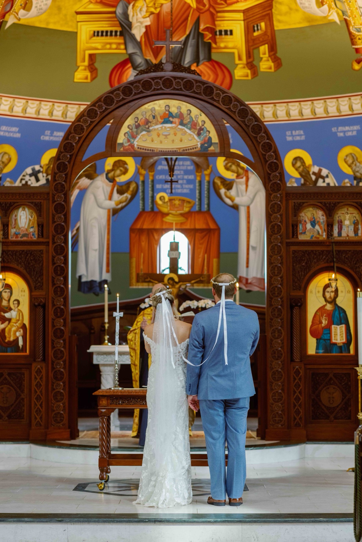 Samantha and James wearing ceremonial crowns during their wedding ceremony inside the mosaic church at The Muses