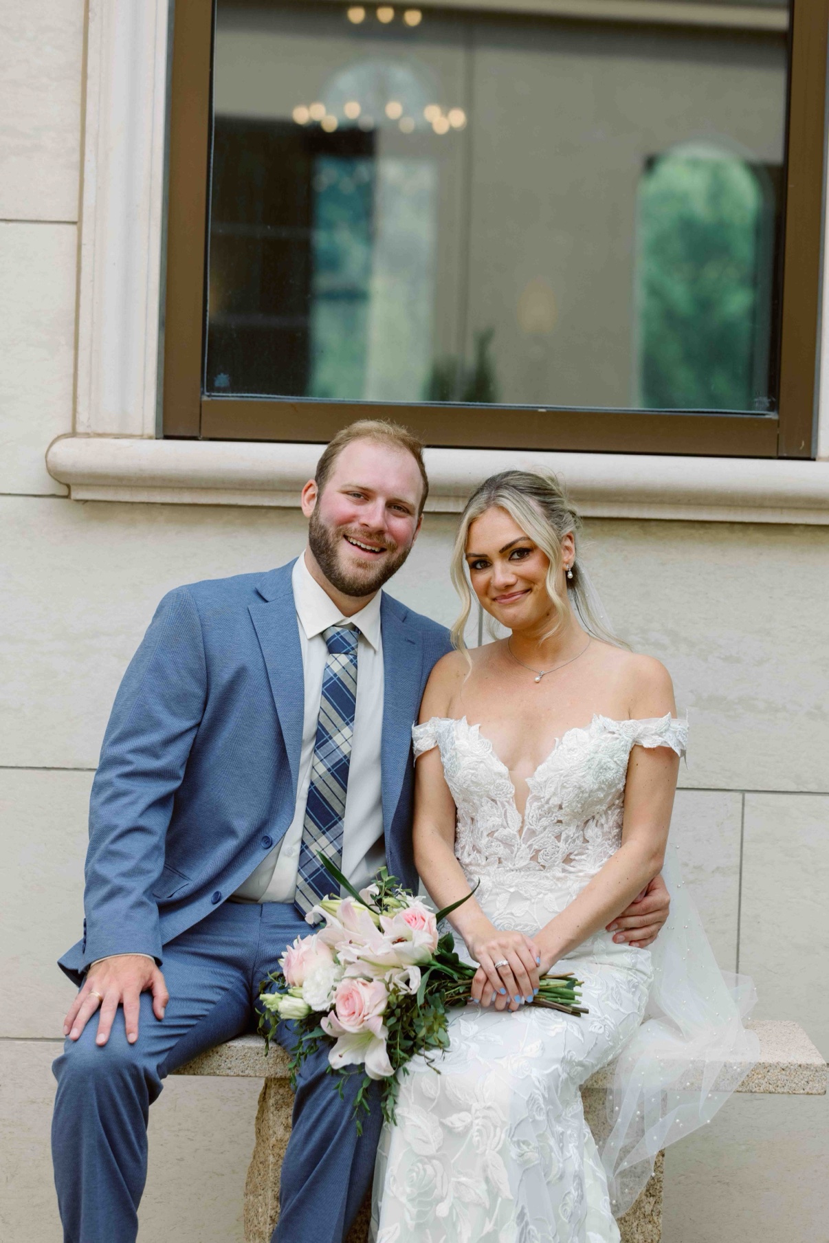 Samantha and James seated together on a stone bench by the window at The Muses in Southampton