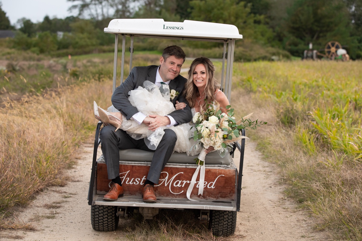 Newlyweds riding together on the Just Married golf cart at The Vineyards at Aquebogue
